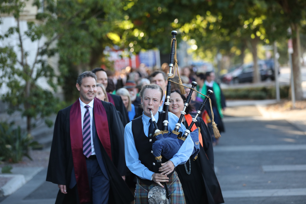 The procession lead by a bag piper to the Lighthouse Theatre.