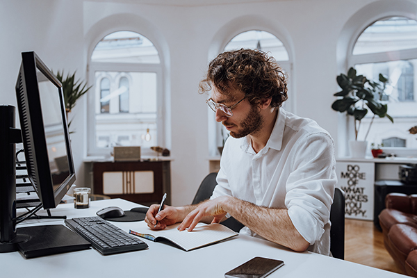 Man concentrating at his work, writing in a journal