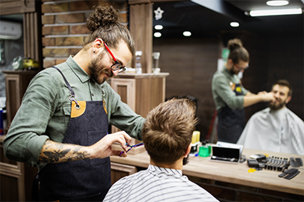 Barber trimming a customer's beard